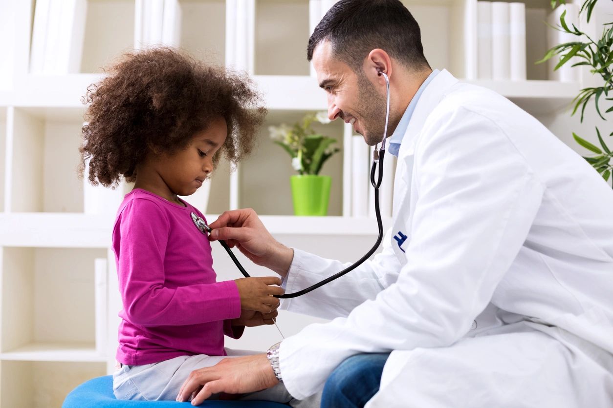 A doctor checking up a little girl